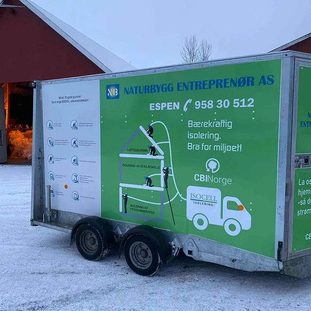 Grønn og hvit tilhenger for blåseisolering fra Naturbygg AS.