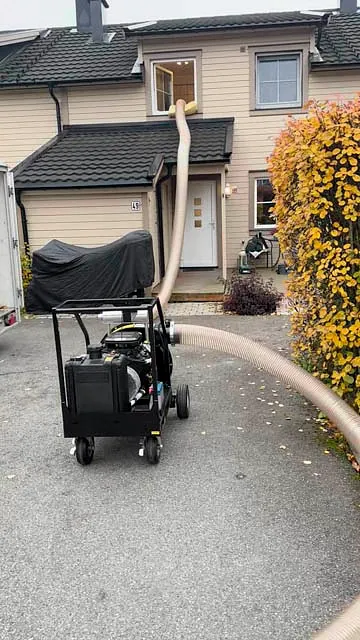 Maskin for blåseisolering parkert utenfor enebolig i Gjerdrum.