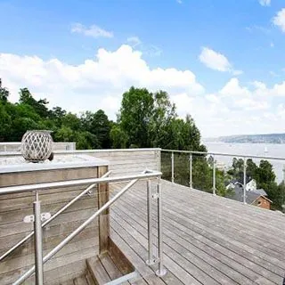  Moderne takterrasse med glassrekkverk og utsikt over sjøen